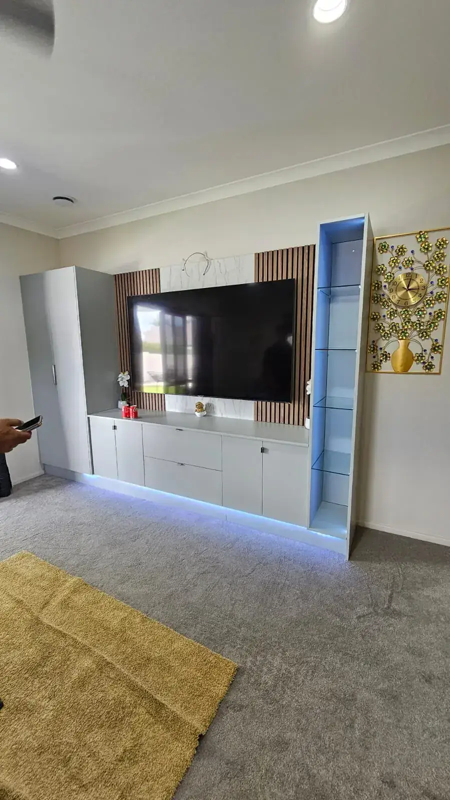 Display media wall with accent LED lighting and built-in storage by Flow Joinery